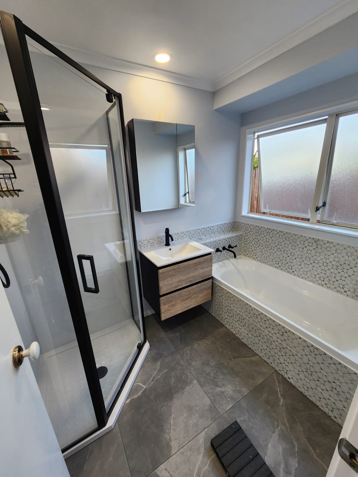 Bathroom after renovation — new shower, vanity and tiling